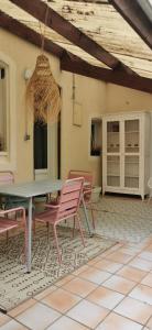 a patio with a table and chairs on a tiled floor at chez Sherlock et Oscar in Bruyères