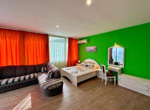 a green room with a bed and a couch at Villa Jackie in Golden Sands
