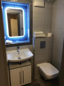 ein Bad mit einem Waschbecken und einem WC mit blauem Licht in der Unterkunft NEON Apartements in Schorndorf + 2 Fotos