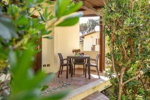 a table and chairs on a patio with trees at Holiday Village in Fondi