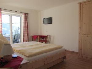 une chambre avec un lit et une télévision au mur dans l'établissement Reitercamp Ortnerhof, à Ramsau am Dachstein