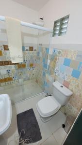a bathroom with a toilet and a sink at Espaço Brilho do Sol Genipabu in Extremóz