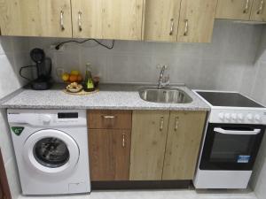 a kitchen with a sink and a washing machine at El portal de Beni in Pedro Bernardo