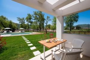 un patio con tavolo, sedie e cortile di Theros Serenity Suites a Olympiada