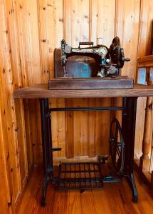 uma velha máquina de costura sentada em cima de uma mesa em 9mouses Chasiotis Guest House em Ampelakia