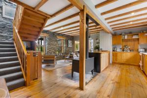 uma cozinha em plano aberto e sala de jantar com pisos em madeira em Judge & Jury Farm Retreat em Gibbston