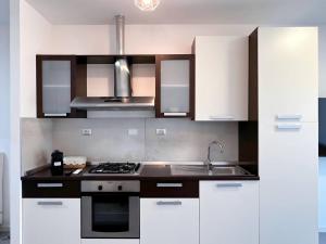 a kitchen with white cabinets and a stove top oven at Non ti scordar di me #1 in Pieris