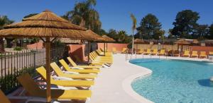 a swimming pool with yellow chairs and a large swimming pool at CAMPING RÊVE DES ILES in Argelès-sur-Mer