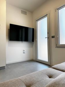 een woonkamer met een flatscreen-tv aan de muur bij Non ti scordar di me #1 in Pieris