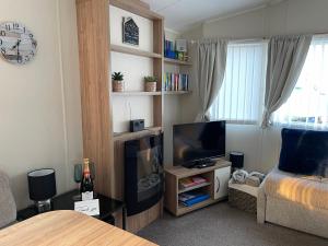 ein Wohnzimmer mit einem TV und einem Sofa in der Unterkunft Olivia Ann in Caernarfon