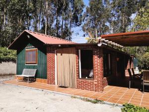 un pequeño cobertizo con un banco en un patio de ladrillo en Cabaña, en Rubayo