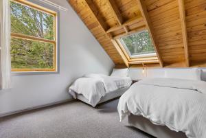 two beds in a white room with a window at Judge & Jury Farm Retreat in Gibbston