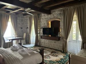 a bedroom with a bed and a tv on the wall at KAŽIN supreme in Kotor