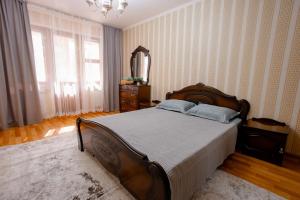 a bedroom with a bed and a dresser and a mirror at 2-х комнатная квартира в центре города по ул.Тәуелсіздік 70 in Kostanay