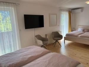 a bedroom with two beds and a flat screen tv on the wall at Rooms Hrominc in Bled