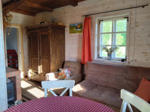 sala de estar con sofá y ventana en A cozy cottage where you can enjoy the peace of the countryside en Salacgrīva