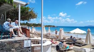 a group of people sitting on the beach at Faedra Beach in Agios Nikolaos