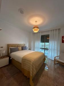 sypialnia z łóżkiem, krzesłem i oknem w obiekcie Apartamento REGIDOR w mieście Cartagena