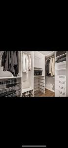 einen begehbaren Kleiderschrank mit weißen Schränken und Kleidung in der Unterkunft Stor leilighet med nydelig utsikt og solforhold in Bergen