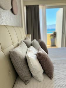 una pila de almohadas en un sofá en una habitación de hotel en Faedra Beach, en Agios Nikolaos