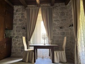 a dining room with a table and chairs and a window at KAŽIN supreme in Kotor