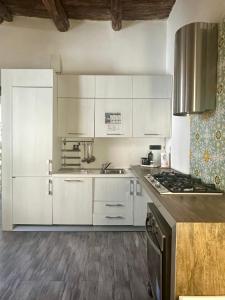 una cucina con mobili bianchi e una stufa di Blue Velvet - Salerno Centro a Salerno Altre 6 foto