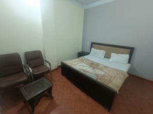a bedroom with a bed and a chair at Hotel Lahore City in Lahore +9 photos