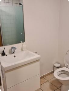 a bathroom with a white sink and a toilet at Værelse til leje 4 in Hørve
