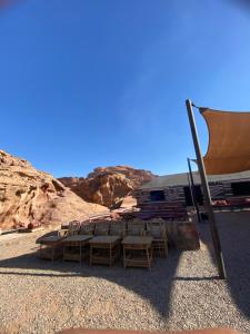 un grupo de sillas y una tienda en el desierto en wadi rum land mars, en Wadi Rum