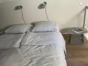 a bed in a bedroom with a side table at Huisje Hendrik in Baarn