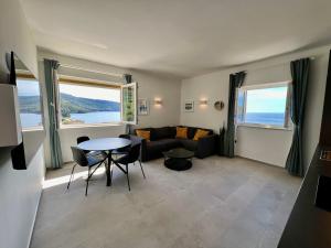 a living room with a couch and a table at Newly Refurbished Komiza Haven in Komiža