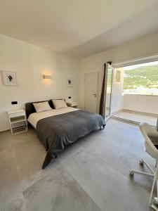 a bedroom with a bed and a large window at Newly Refurbished Komiza Haven in Komiža