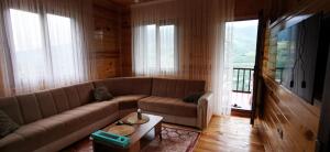 a living room with a couch and a table at Kozalak Forest Mansion in Akcaabat