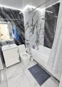 uma casa de banho com um WC, uma banheira e um lavatório. em 3х-ком Люкс в центре Шымкента Проспект Б Момышулы 4 em Shymkent