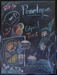 a chalkboard with a plate of food on it at Penelope Apartment Hotel in Dassia