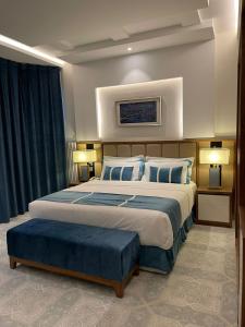 een grote slaapkamer met een groot bed met blauwe kussens bij كيان ان Kian N in Khamis Mushayt