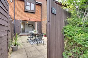 a patio with a table and chairs next to a building at Seapoint- Boho Coastal Retreat near Sandbanks! in Poole