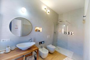 ein Badezimmer mit einem Waschbecken, einem WC und einem Spiegel in der Unterkunft Cozy guest house Downtown in Olbia