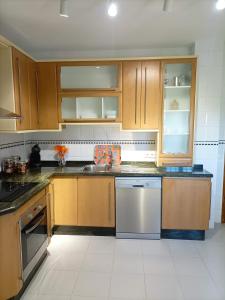 a kitchen with wooden cabinets and a sink and a dishwasher at Villa Matisse Luxury Beach in Torremolinos