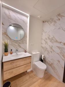a bathroom with a toilet and a sink and a mirror at Balcón del Malecón in Murcia