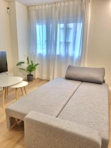 a bedroom with a couch and a table and a window at Balcón del Malecón in Murcia