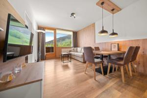 uma cozinha e sala de jantar com mesa e cadeiras em Luxus Apartment Kaprun View em Kaprun
