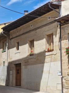 um edifício de pedra com janelas e flores em Casa de la tía Irene em Briñas
