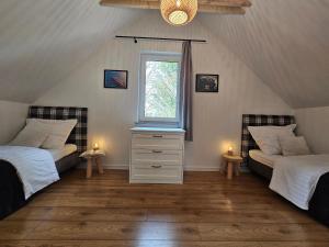 a attic bedroom with two beds and a window at North Port in Kopalino