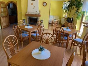 a dining room with tables and chairs and a fireplace at Vila Marko in Nová Lesná