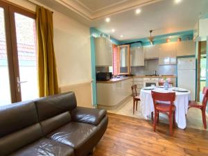 ein Wohnzimmer mit einem Sofa und einem Tisch in der Küche in der Unterkunft Appartement/maison avec jardin in Noisy-le-Sec + 3 Fotos