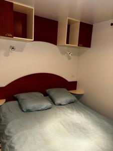 um quarto com uma cama com duas almofadas em camping Capbreton lapointe em Capbreton