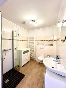 a white bathroom with a sink and a toilet at Schlafen beim Sandmann in Dörpen