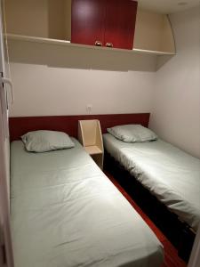 2 camas individuais num pequeno quarto com em camping Capbreton lapointe em Capbreton