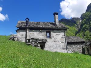 an old stone house sitting on a grassy hill at Rustico Rosso di Ribia 